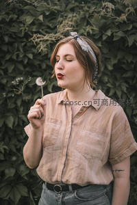 少女轻吹蒲公英许愿瞬间