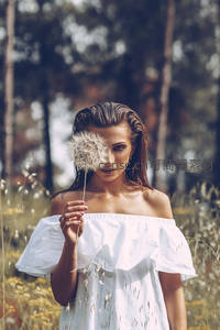 林间白衣女子用蒲公英遮面，清新脱俗