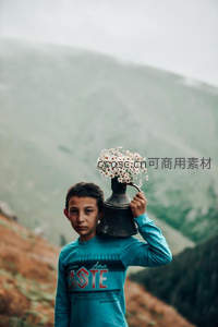 少年肩扛花瓶，山间漫步