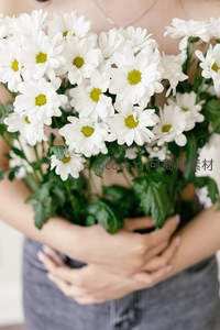怀抱一束盛开的白色雏菊