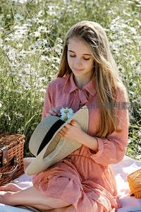 少女野餐于雏菊花海，手拿草帽