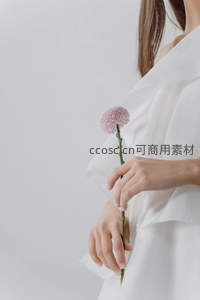 白衣女子手捧淡紫小花，温柔静谧