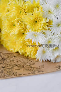 黄白菊花束与花卉图案包装纸的细节