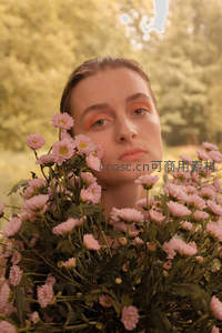 女子被粉色菊花环绕置身暖调森林