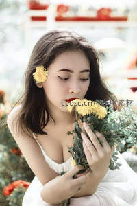 女子轻嗅黄菊，发间花饰映红唇