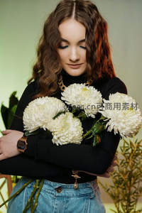女子怀抱白色菊花微笑闭目