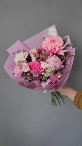 手握精致花束，粉紫包装映衬娇艳花朵