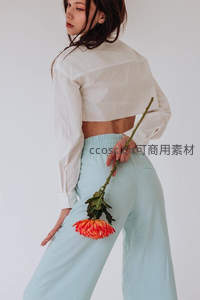 白衫蓝裤持花，背影时尚随性