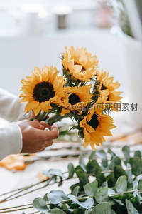 双手捧着一束新鲜向日葵传递温暖