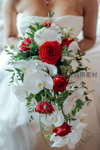 新娘手捧红白玫瑰与兰花的华丽花束
