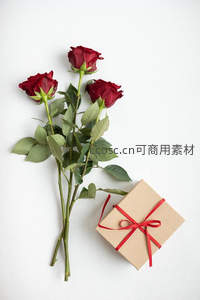 三朵红玫瑰与礼盒并置，纯白背景显雅致