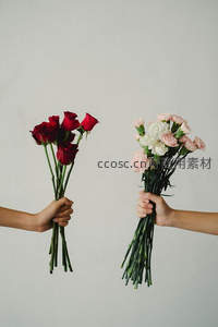双手捧着红玫瑰与康乃馨花束