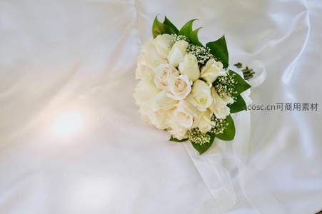 白色玫瑰新娘手捧花置于绸缎之上