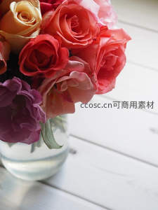 多彩玫瑰花束静置于白色木桌之上