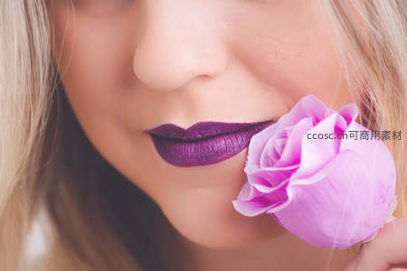紫唇女子轻吻粉玫瑰的优雅侧颜
