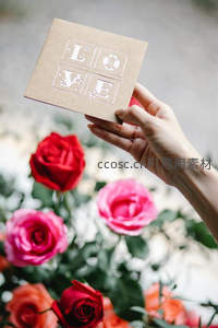 手捧LOVE卡片与玫瑰花海的浪漫瞬间