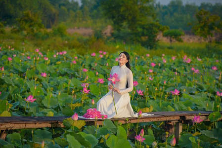 白衣女子坐木桥赏荷闭目沉思