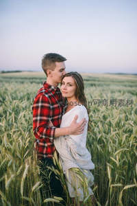 情侣相拥于碧绿麦田，爱意浓浓