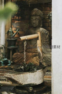 竹水滴落佛像前，禅意庭院静谧时