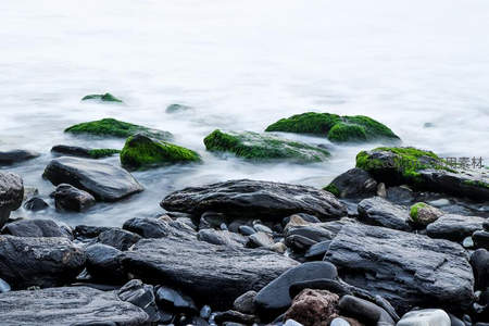 海浪轻抚长满青苔的礁石