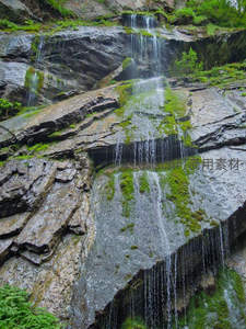岩壁上细流涓涓的苔藓瀑布