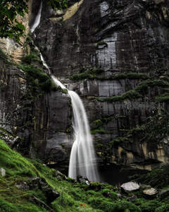 悬崖飞瀑直落深谷，苍翠草甸映衬壮美