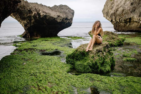 绿藻海岸，女子静坐巨岩之上