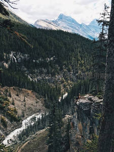 悬崖边的旅人，远眺雪山峡谷壮丽风景
