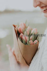 微笑女子怀抱粉色郁金香花束