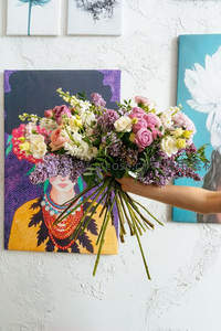 手捧缤纷花束遮住画中人脸，艺术与自然交融