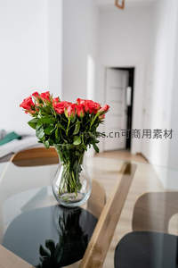 现代客厅玻璃桌上的一束红玫瑰