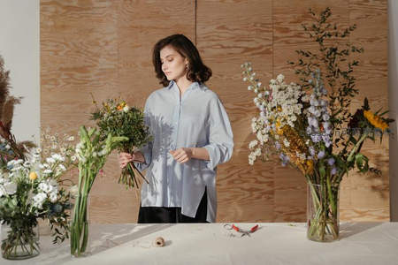 花艺师在木质背景前精心搭配花束