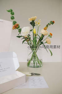 透明花瓶中插着淡雅花束的桌面布置