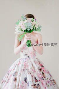 新娘以花束遮面身穿印花礼服