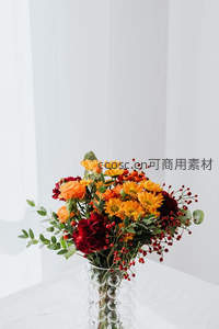 秋日暖色花束，橙黄菊花与红浆果在玻璃瓶中绽放