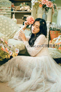 长裙女子闭目轻嗅粉色花朵沉浸花海