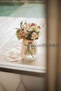 泳池边木桌上的柔美新娘捧花