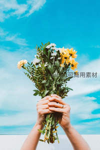 双手捧花向蓝天献上美好祝愿