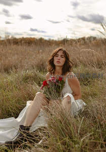 女子草地上坐拥红玫瑰，野性浪漫