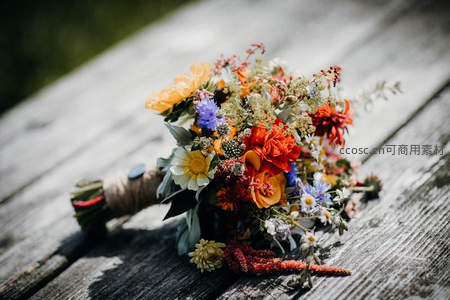 多彩野花手捧花束置于木桌之上