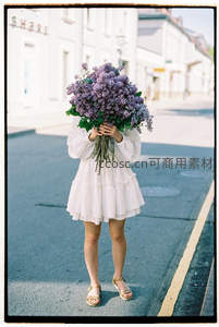 街头少女手捧紫丁香遮面微笑