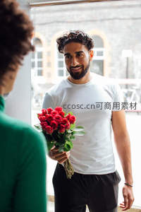 男子手持红玫瑰深情送礼