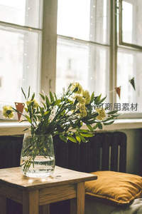 窗边木桌上的黄花绿植静景