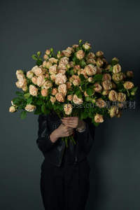 黑衣人怀抱巨型浅粉玫瑰花束遮面神秘优雅