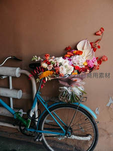 复古蓝自行车载满缤纷花束