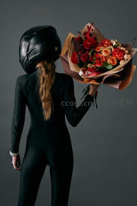 头戴头盔手持花束的神秘背影