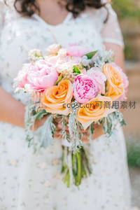 少女怀抱粉橙玫瑰与牡丹的春日花束