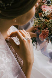 新娘轻抚颈链凝视缤纷捧花