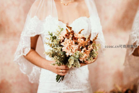 新娘怀抱干花捧花，头纱轻覆肩头