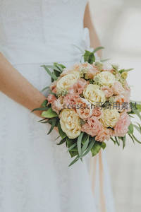 新娘手捧粉黄玫瑰花束，绿叶点缀清新